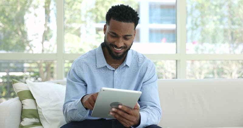 African man looking at digital tablet screen browsing wireless internet