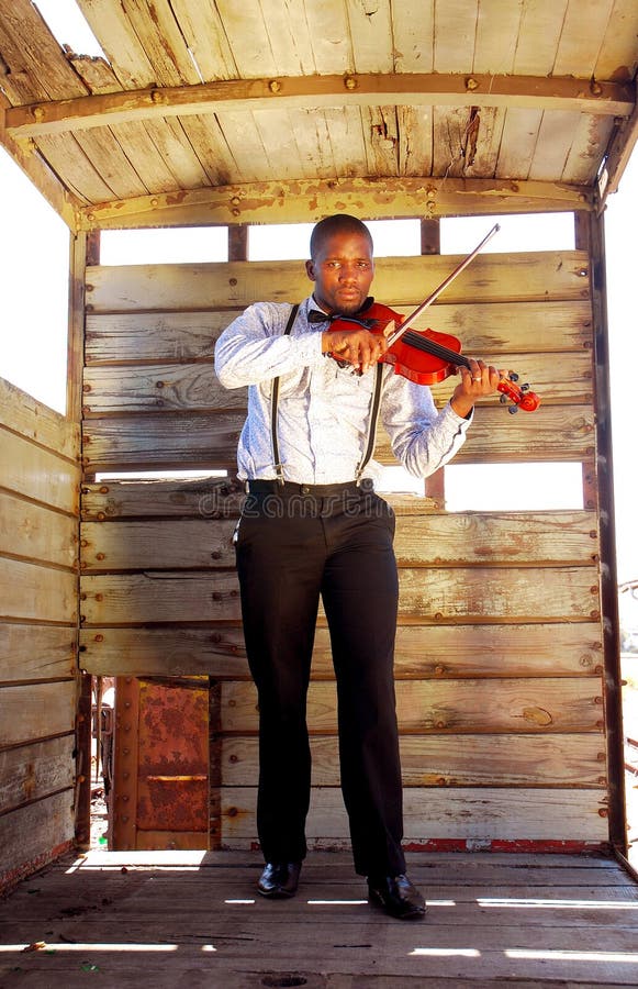 Čierna Južnej Afriky umelec prehrávanie hudby na jeho husle v starej opustenej vlak vozňov.