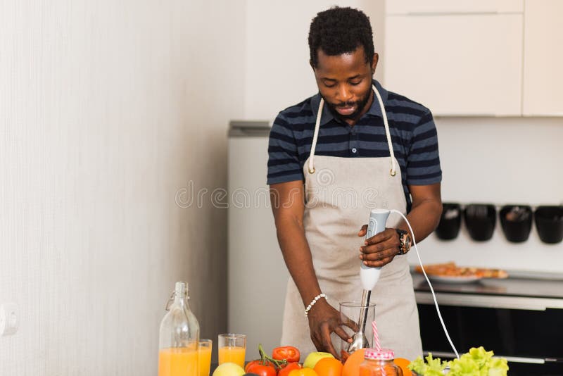 African man preparing healthy food at home in kitchen stock photos African man preparing healthy food at home in kitchen stock photos