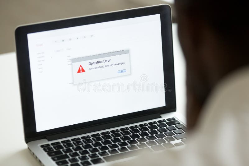 African man using laptop with application failure message on scr stock photos