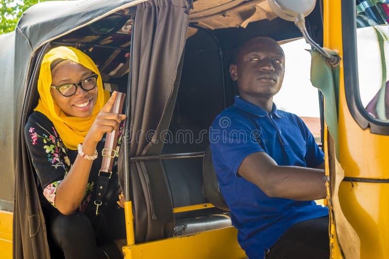 african men driving a auto rickshaw taxi being annoyed by a female passenger who& x27;s talking to him, nigeria, nigerian, young, youth, black, person, guy, tuk, keke, napep, transport, transportation, vehicle, driver, local, lifestyle, smiling, cheerful, town, job, livelihood, lady, woman, muslim, happy, excited, excitement, directions, showing, point, pointing, destination, route, sitting, annoying, angry, irritating, frustrated. african men driving a auto rickshaw taxi being annoyed by a female passenger who& x27;s talking to him, nigeria, nigerian, young, youth, black, person, guy, tuk, keke, napep, transport, transportation, vehicle, driver, local, lifestyle, smiling, cheerful, town, job, livelihood, lady, woman, muslim, happy, excited, excitement, directions, showing, point, pointing, destination, route, sitting, annoying, angry, irritating, frustrated