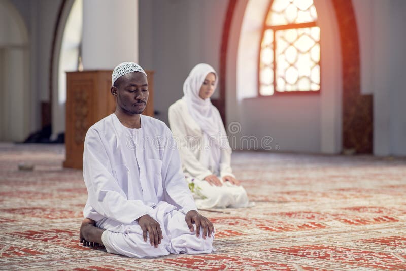 African Muslim Couple Praying inside of beutiful mosque stock images
