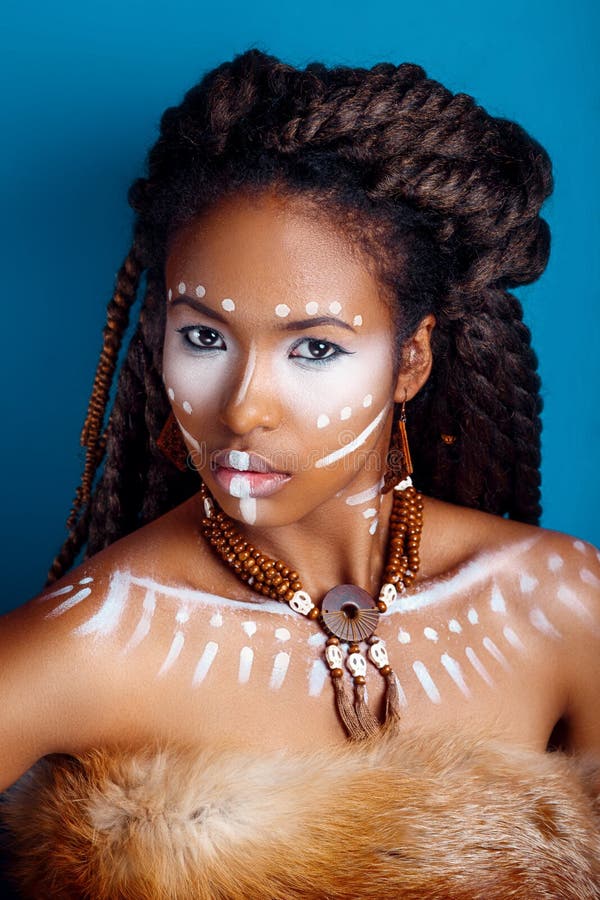 African style . Attractive young woman in ethnic jewelry . close up portrait of a woman with a painted face. Creative make up.