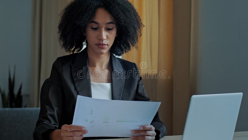African teacher worker business woman work with graphics documents at home office check documentation enter financial