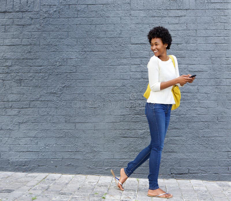 African woman with a cell phone looking over her shoulder