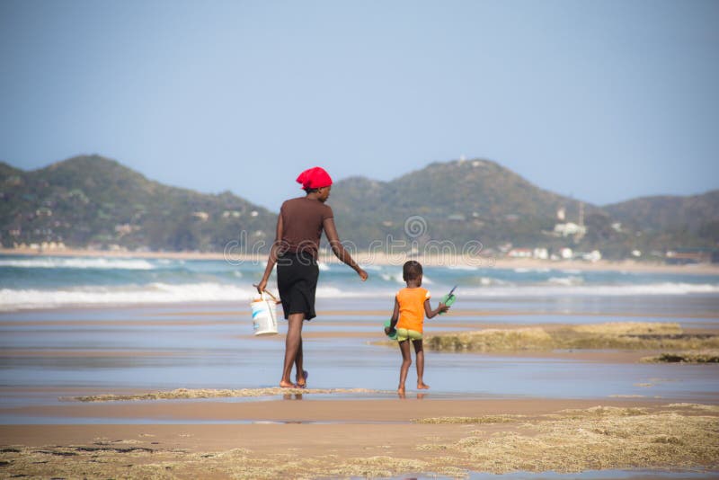 African woman and child walking on the beach stock images African woman and child walking on the beach stock images