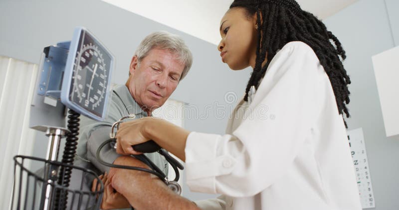 African woman doctor checking patient's blood pressure stock photo African woman doctor checking patient's blood pressure stock photo