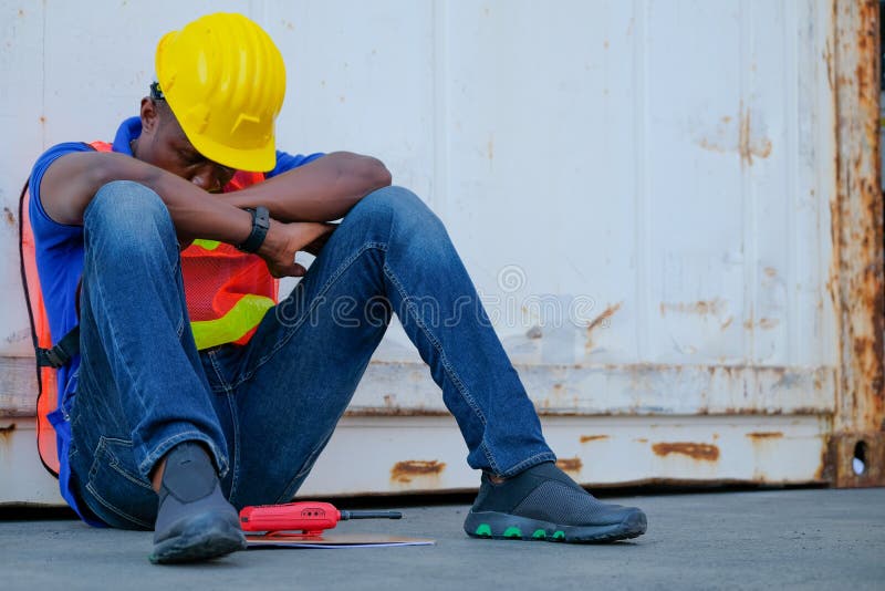 African worker man sit close to cargo container and he look tire and also sleepy stock photo African worker man sit close to cargo container and he look tire and also sleepy stock photo