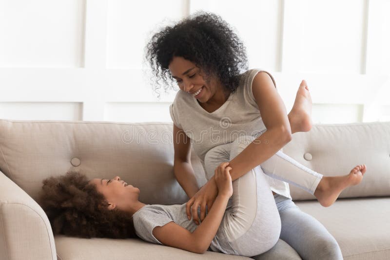 Dad Tickles Daughter Played With Girl On Bed At Home Stock Photo