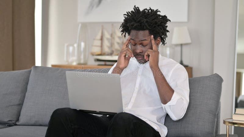 Africano cansado com dor de cabeça em casa foto de stock