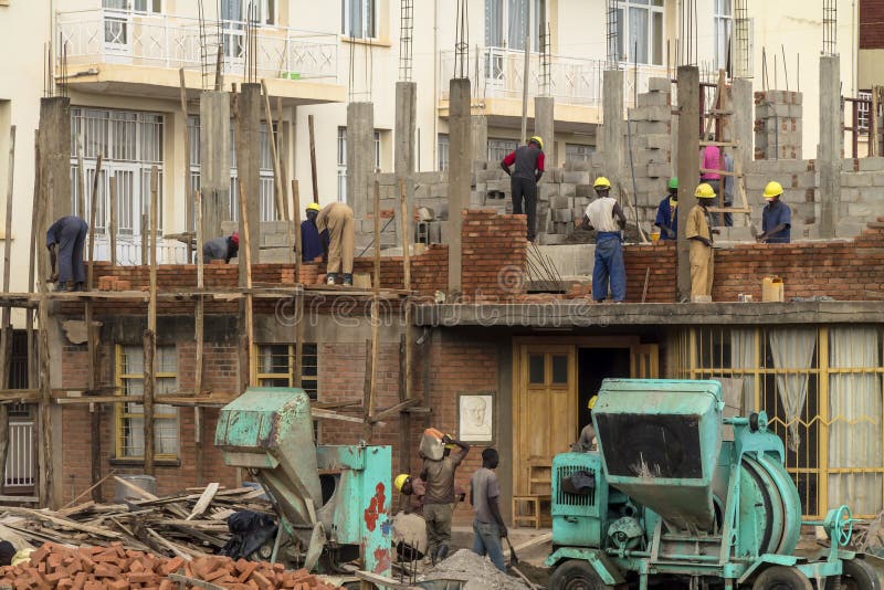 KIGALI, RWANDA - NOVEMBER 14, 2013: Unidentified men at work in the construction of a building in Kigali on November 14, 2013, Kingali, Rwanda. KIGALI, RWANDA - NOVEMBER 14, 2013: Unidentified men at work in the construction of a building in Kigali on November 14, 2013, Kingali, Rwanda