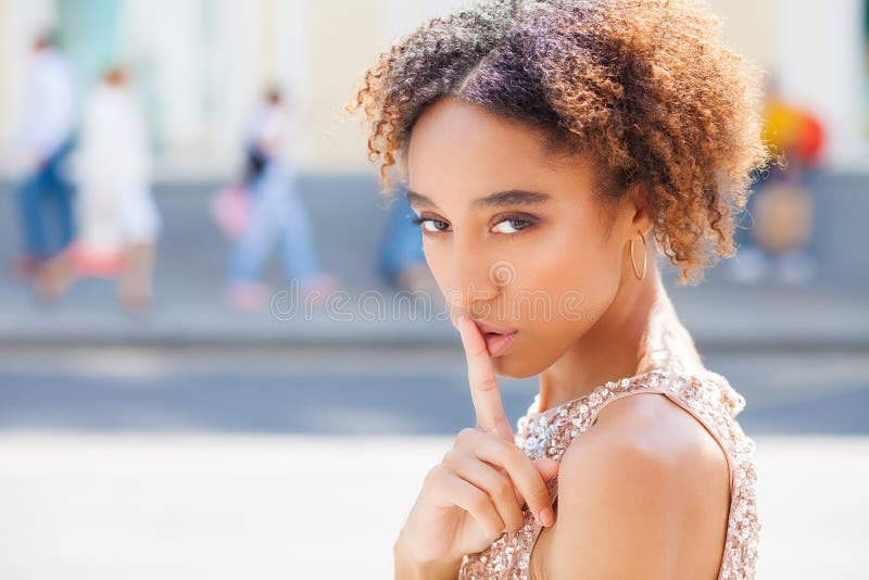 Afrikaans Amerikaans meisje of jonge vrouw die kleding met haar vinger op haar lippen dragen die om stilte vragen of een geheim h stock afbeeldingen Afrikaans Amerikaans meisje of jonge vrouw die kleding met haar vinger op haar lippen dragen die om stilte vragen of een geheim h stock afbeeldingen