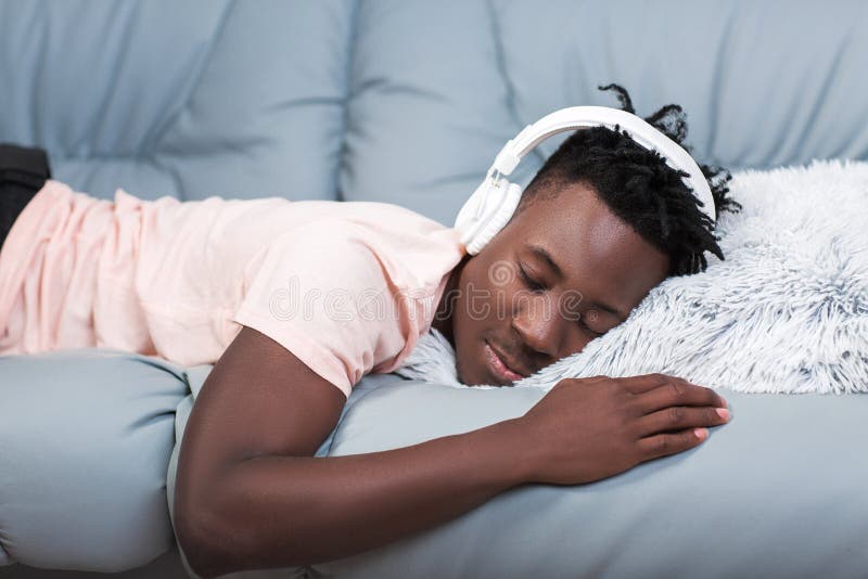 Afrikaans-Amerikaanse mens die in hoofdtelefoons aan muziek luisteren royalty-vrije stock fotografie Afrikaans-Amerikaanse mens die in hoofdtelefoons aan muziek luisteren royalty-vrije stock fotografie