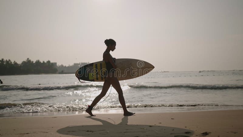 Afrikaans - amerikaanse vrouw die met een surfplank op het strand op de oceaan rondloopt. zwarte vrouwelijke surfer met surfplank.