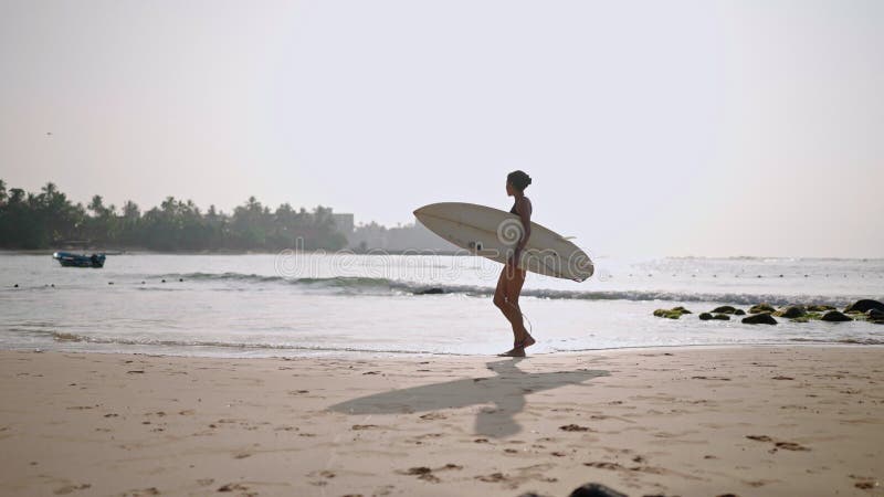 Afrikaans - amerikaanse vrouw die met een surfplank op het strand op de oceaan rondloopt. zwarte vrouwelijke surfer met surfplank.