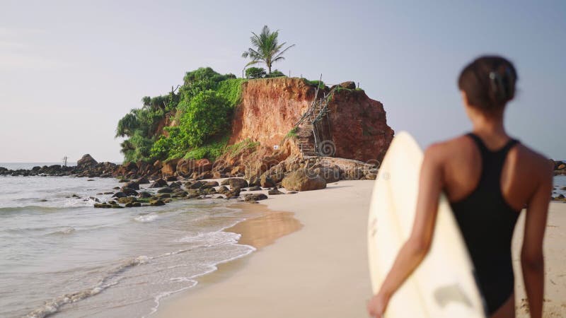 Afrikaans - amerikaanse vrouw die met een surfplank op het strand op de oceaan rondloopt. zwarte vrouwelijke surfer met surfplank.