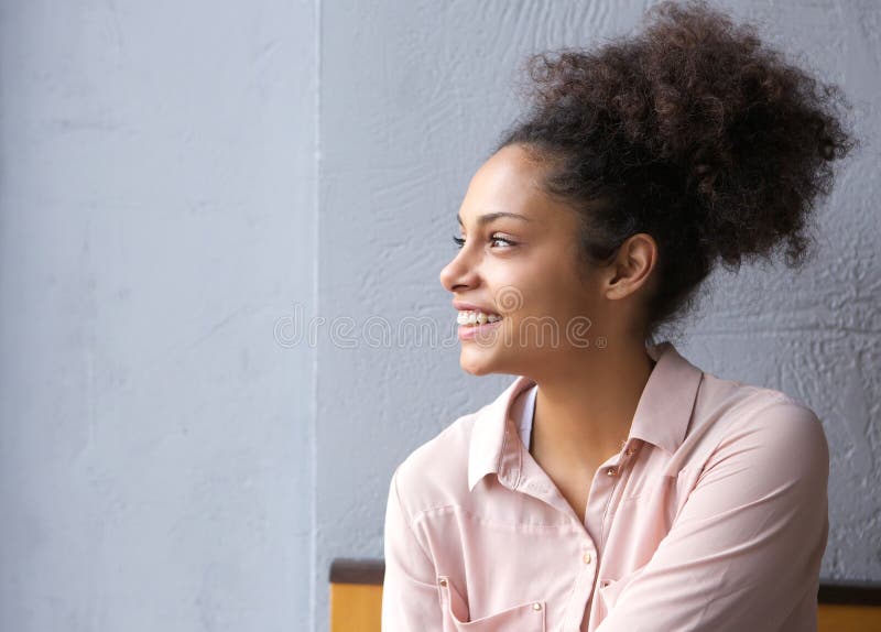 Close up portrait of a cheerful young african american woman smiling and looking away. Close up portrait of a cheerful young african american woman smiling and looking away