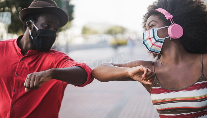 Afrikaanse mensen die gezichtsmaskers dragen terwijl ze hun ellebogen tegen het lijf lopen in plaats van groeten met een grote soc