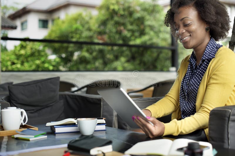 Afrikanerin, die Tablet-Entspannungs-Konzept verwendet stockfotografie