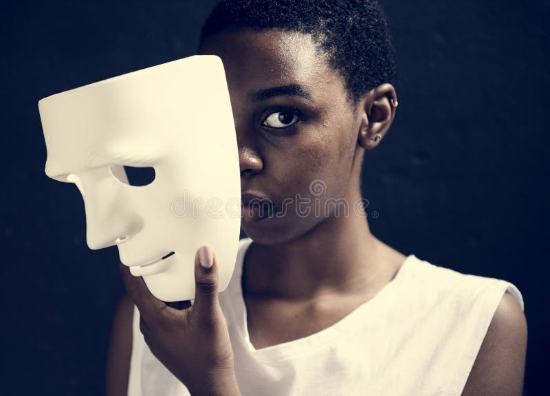 Afrikanische Frau, die eine weiße Maske hält stockbilder