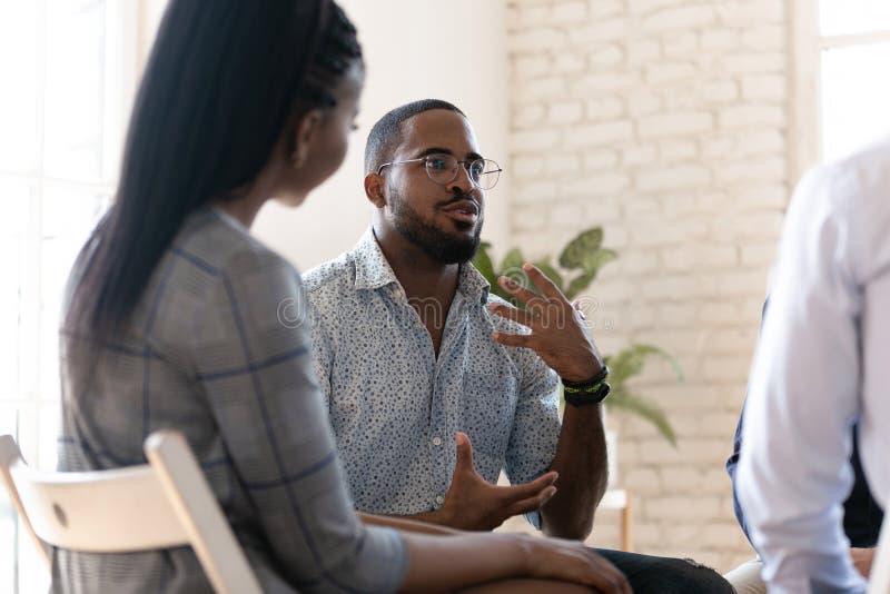 Afrikanisch-amerikanischer Mann spricht in Gruppentherapiesitzung lizenzfreie stockfotos