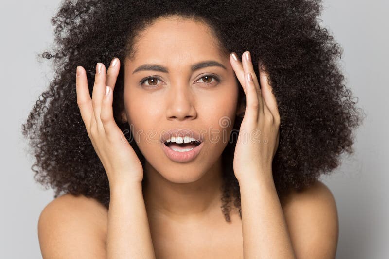 Afrikanische Amerikanerin berührt Gesicht nach Hautpflege