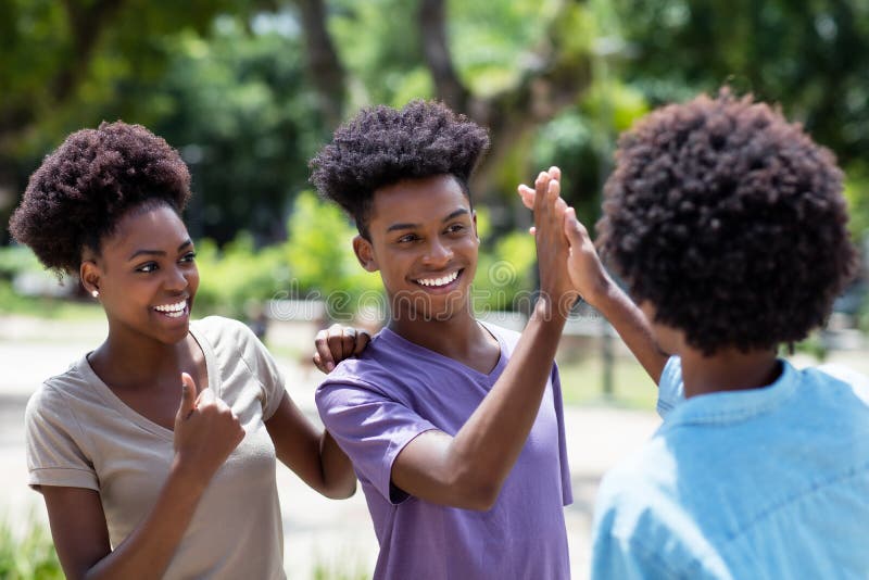 Afrikanische amerikanische junge Erwachsene geben hohe fünf an Freunde mit afhaar