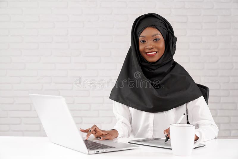 Afrikanische moslemische Geschäftsdame, die an Computer im Büro arbeitet lizenzfreie stockbilder Afrikanische moslemische Geschäftsdame, die an Computer im Büro arbeitet lizenzfreie stockbilder