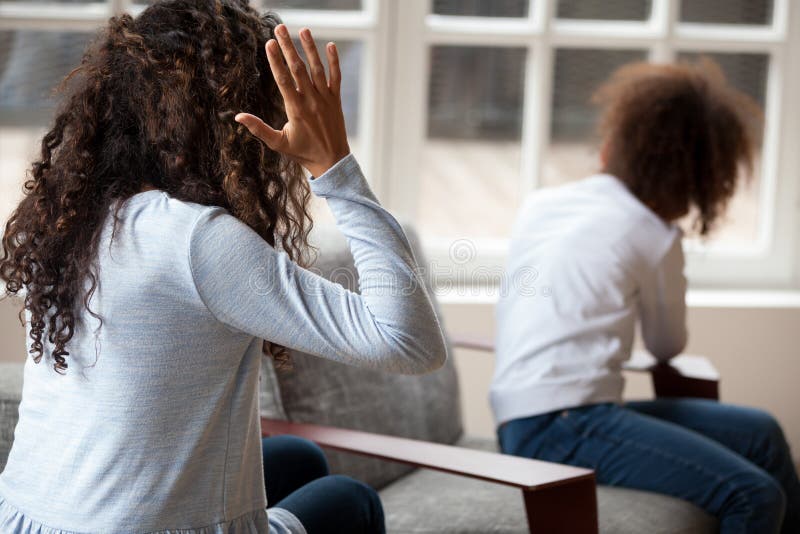 Afrikanische Mutter der hinteren Ansicht, die mit Tochter streitet stockbild Afrikanische Mutter der hinteren Ansicht, die mit Tochter streitet stockbild