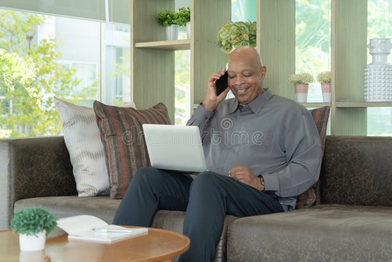 Afrikanische Person des älteren alten älterer, schwarzer amerikanischen Mannes des Unternehmens mithilfe eines Smartphone oder ein stockfotografie