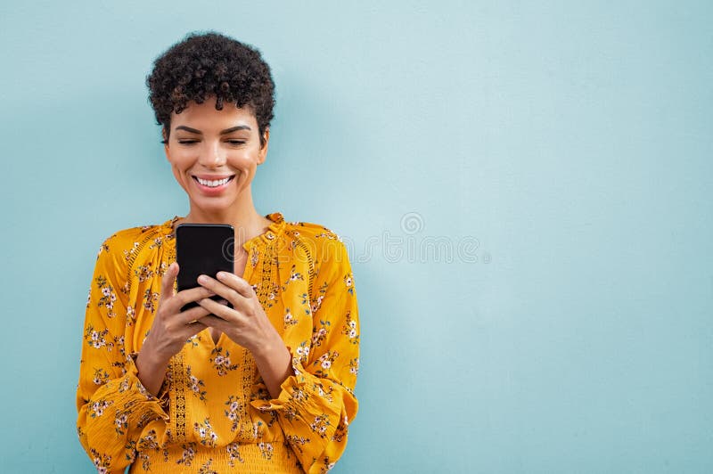 Afrikanische stilvolle Frau, die intelligentes Telefon verwendet stockbild