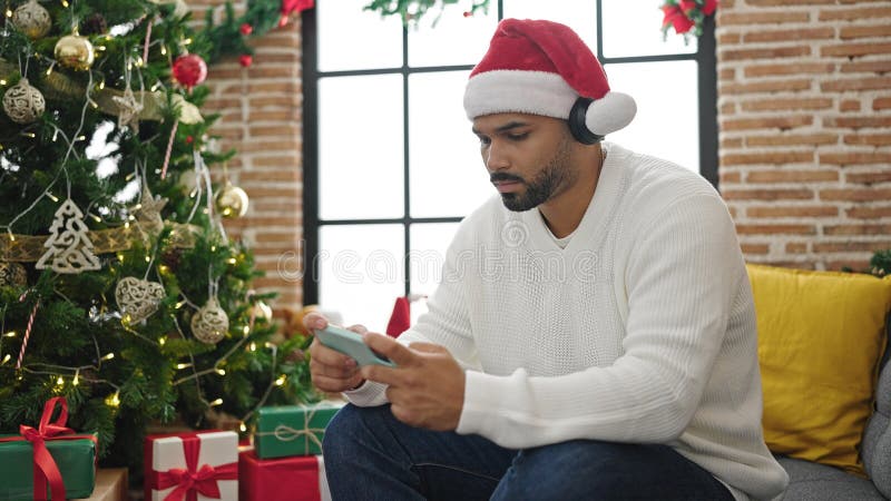 Afrikanischer Amerikaner feiert Weihnachten mit Smartphone zu Hause stockfotografie