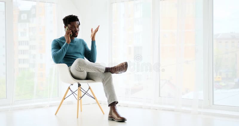 Afrikanischer amerikaner sprechen auf handy sitzen auf stuhl