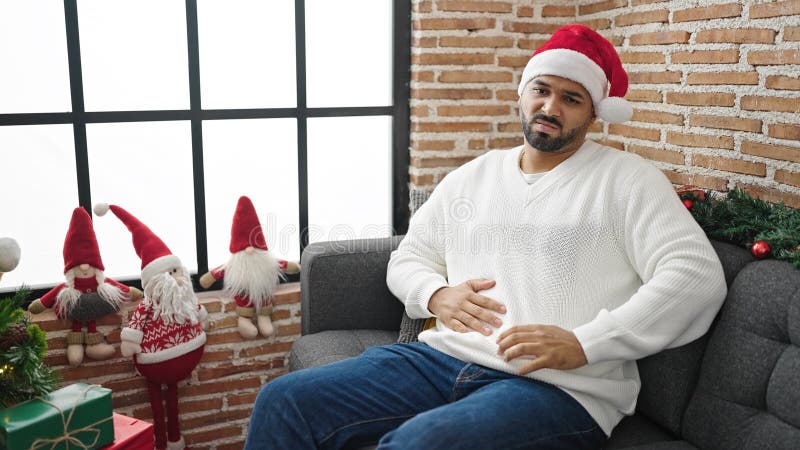 Afrikanischer amerikanischer Mann mit Bauchschmerzen und Weihnachtsmütze zu Hause stockfoto