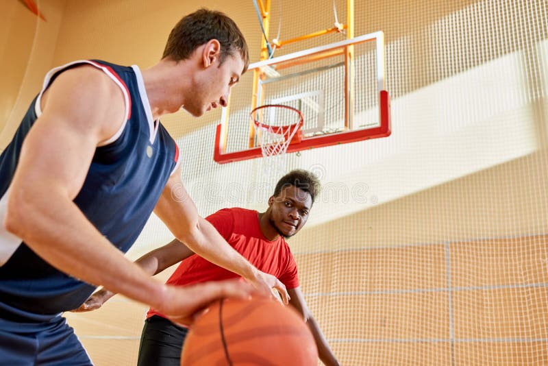 Afrikanischer Spieler, der seinen Korb auf Gericht schützt lizenzfreie stockfotografie Afrikanischer Spieler, der seinen Korb auf Gericht schützt lizenzfreie stockfotografie