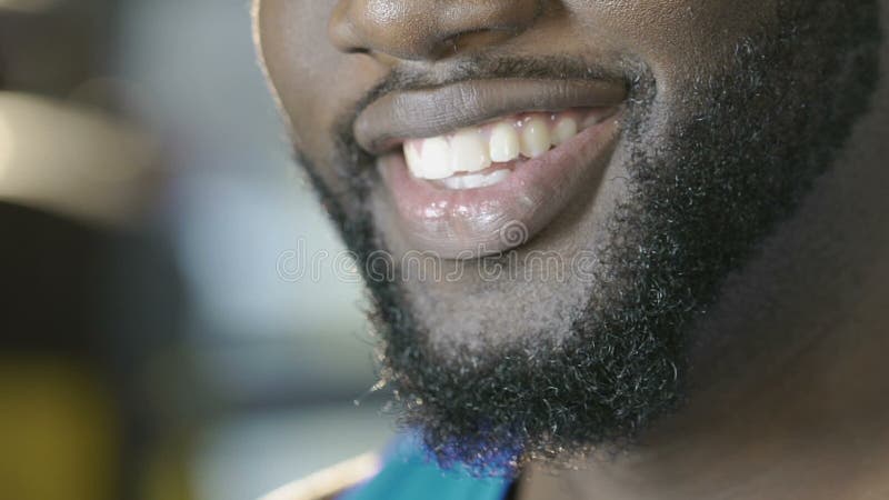 Afrikansk amerikan som vänder upp hans framsida till kameran som ger härligt brett leende