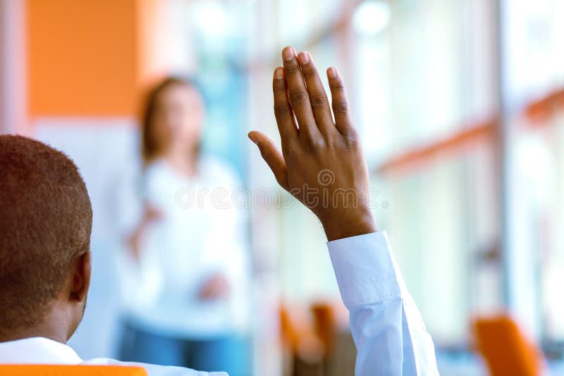 Afrikansk amerikanaffärsfolk som där upp lyfter handen på en konferens för att svara en fråga royaltyfria bilder Afrikansk amerikanaffärsfolk som där upp lyfter handen på en konferens för att svara en fråga royaltyfria bilder