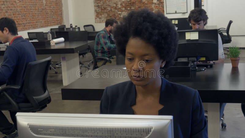 Afrikansk amerikanaffärskvinna som arbetar den skrivbords- datoren stock video