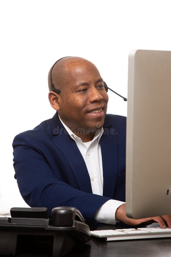 Afrikansk amerikanaffärsman Sitting In Front av datoren royaltyfri bild Afrikansk amerikanaffärsman Sitting In Front av datoren royaltyfri bild