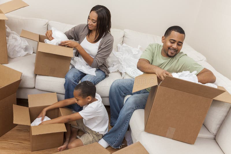 Afrikansk amerikanfamilj som packar upp askar som flyttar huset royaltyfri foto Afrikansk amerikanfamilj som packar upp askar som flyttar huset royaltyfri foto
