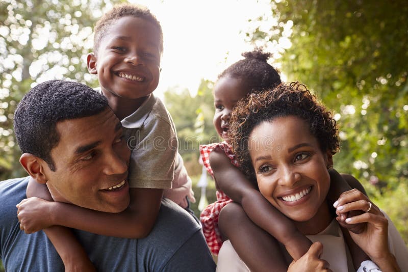 African American parents giving children piggyback rides. African American parents giving children piggyback rides