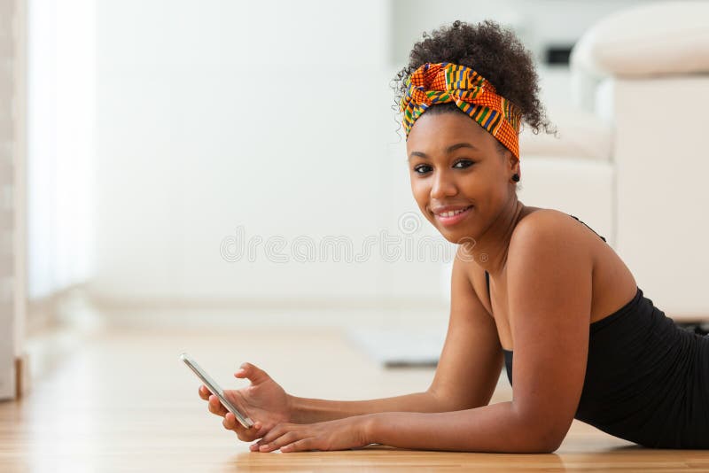 Afrikansk amerikankvinna som överför ett textmeddelande på en mobiltelefon fotografering för bildbyråer Afrikansk amerikankvinna som överför ett textmeddelande på en mobiltelefon fotografering för bildbyråer