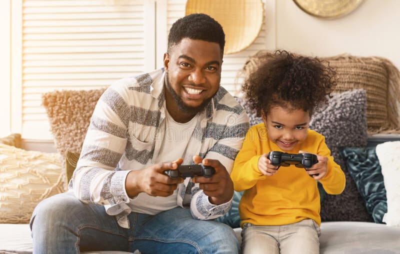 Afrikansk amerikansk far och dotter spelar dataspel royaltyfria foton