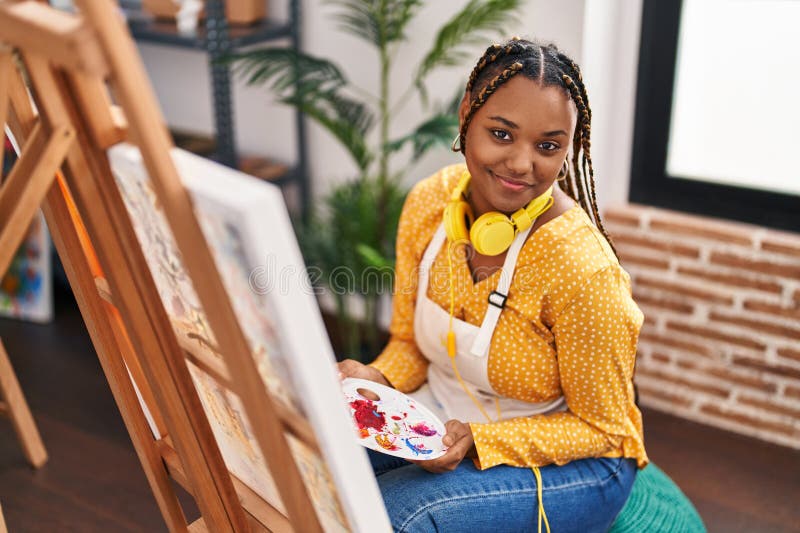 Afrikansk amerikansk konstnär som leker självsäker ritning på konststudio royaltyfri foto