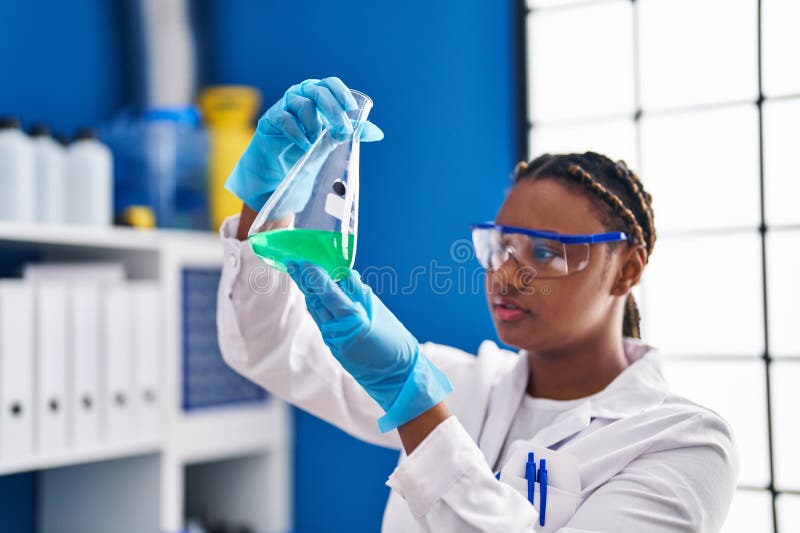 Afrikansk amerikansk kvinnlig forskare som håller provrör på laboratorium royaltyfri bild