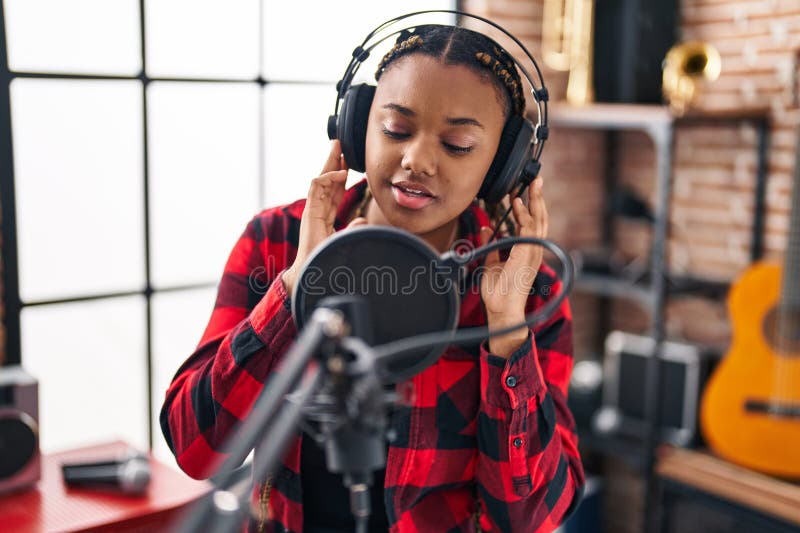 Afrikansk amerikansk musiker sjunger låt i musikstudio fotografering för bildbyråer