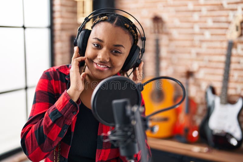 Afrikansk amerikansk musiker som leker självsäker sångmusik i musikstudio arkivfoto