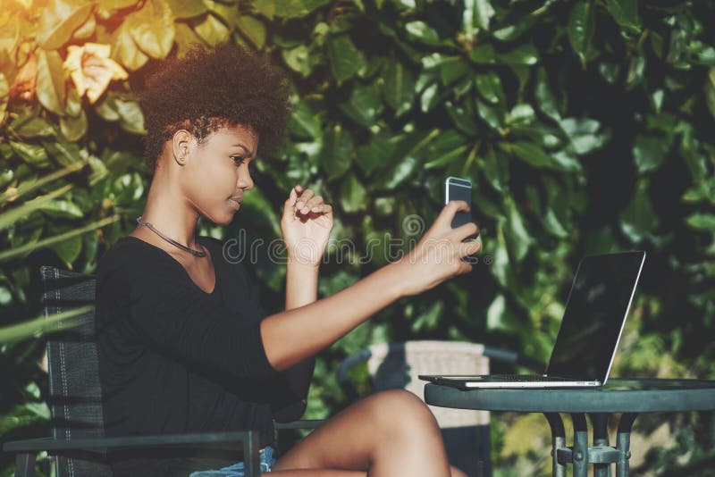 Afrikansk amerikanstudentflicka som utomhus tar selfie royaltyfria foton Afrikansk amerikanstudentflicka som utomhus tar selfie royaltyfria foton