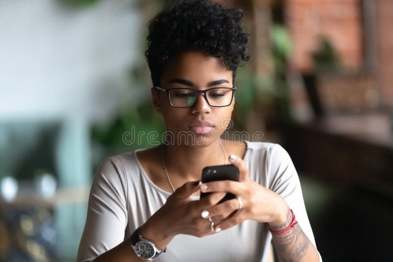 Afrikansk flicka i glasögon med mobilchatt royaltyfria bilder Afrikansk flicka i glasögon med mobilchatt royaltyfria bilder