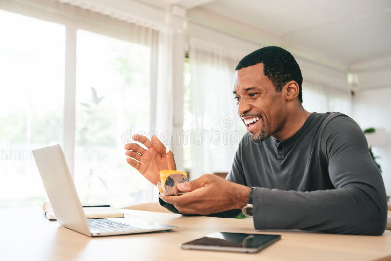 Afro-americano sorridente fa videochiamate e festeggia il compleanno online sul portatile fotografie stock libere da diritti